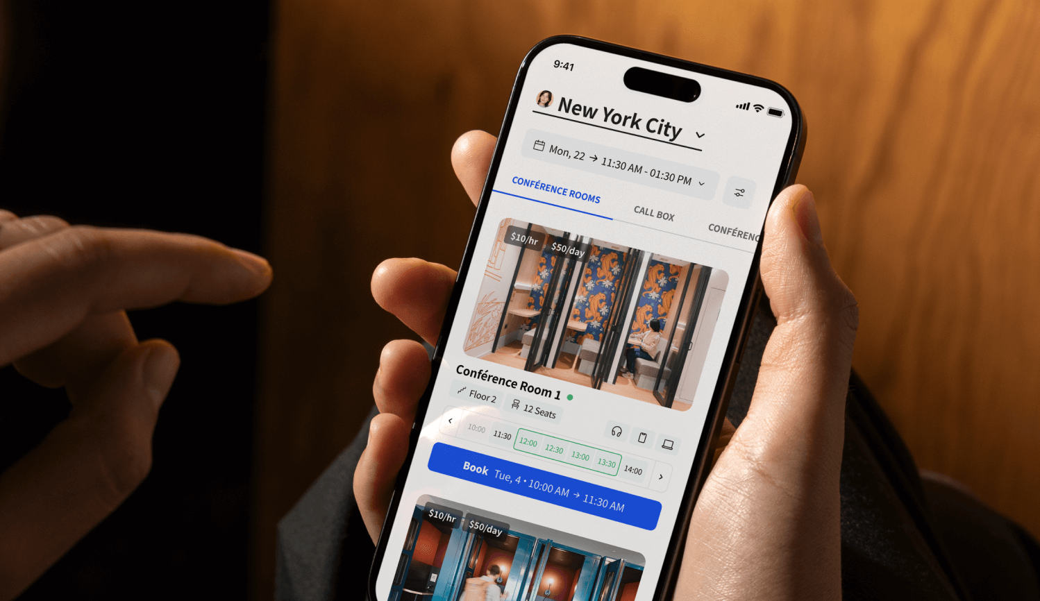 Close-up of a person holding and using a smartphone with the Archie coworking mobile app.